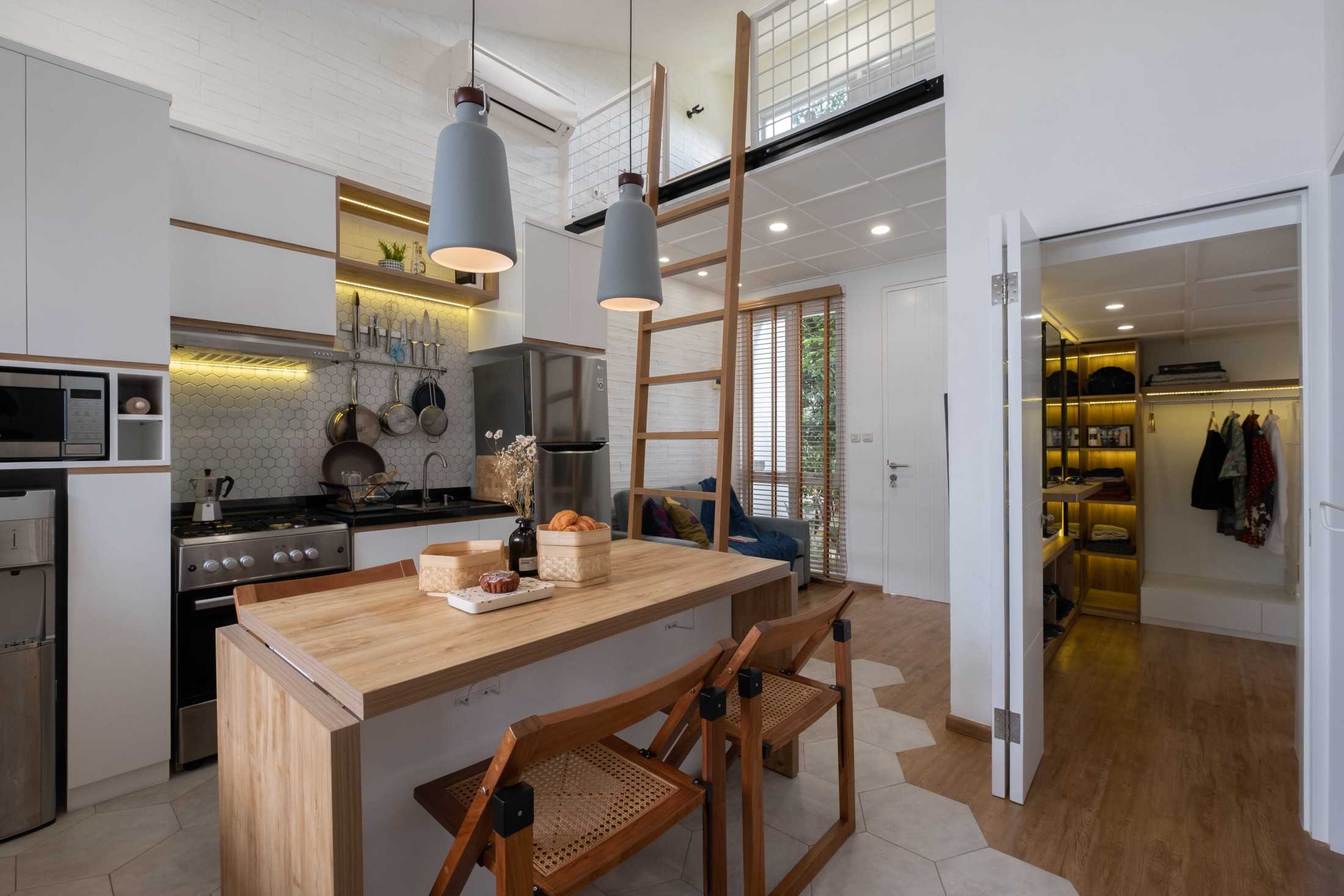 Walk-in closet di sini menjadi ruang khusus untuk menyimpan pakaian, seprai, dan handuk, sekaligus ruang untuk berpakaian dan berhias. Tidak semua rumah memilikinya. Biasanya karena alasan keterbatasan ruang. Namun, rumah mungil ini memiliki walk-in closet yang cukup lengkap dengan area pergerakan yang nyaman. Di dalam walk-in closet ini juga ada tangga menuju lantai atas.