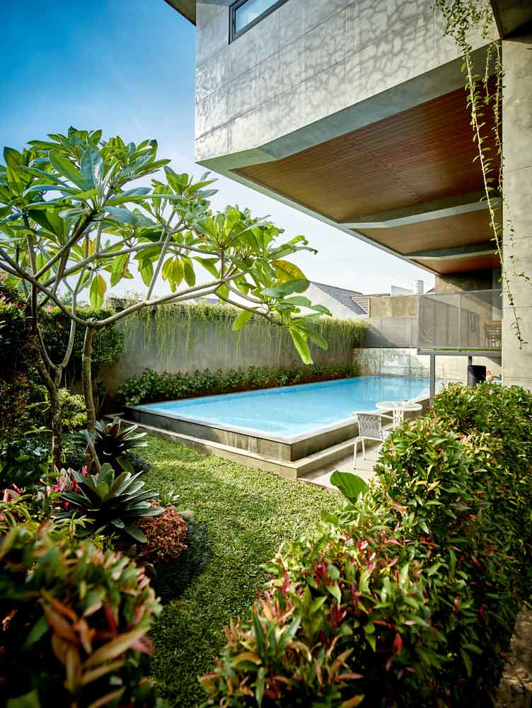Taman tropis yang rimbun di sisi kolam renang // Archdaily.com